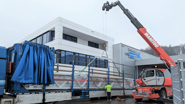 Die 16 m langen Fachwerkträger werden in einem Stück verladen und transportiert. (Bildrechte bei GEMÜ Schweiz und Schilling Engineering GmbH)