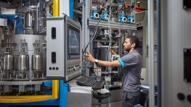 Ein Mitarbeiter von Endress+Hauser Flow in Reinach, Schweiz, bedient eine Kalibrieranlage. / An employee of Endress+Hauser Flow in Reinach, Switzerland, operates a calibration facility.