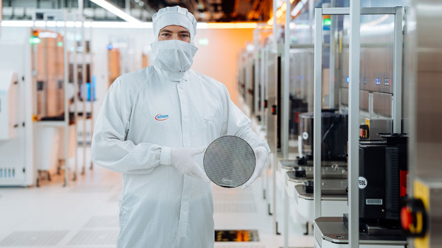 Ein Techniker im Reinraum von Infineon Technologies in Villach, Österreich, hält einen 200 mm Siliziumkarbid-Wafer. / A technical engineer in the cleanroom at Infineon Technologies in Villach, Austria, holds a 200 mm silicon carbide wafer.